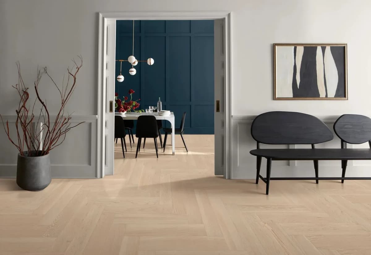 Anderson Tuftex European ash flooring in a herringbone pattern meets an open doorway leading to a dining room.