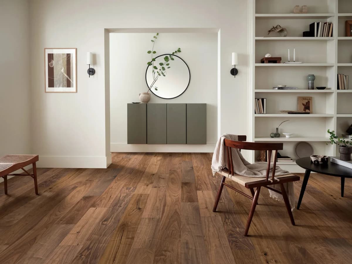 Anderson Tuftex American walnut flooring in Era grounds a modern living room with rich brown tones and bold grain.