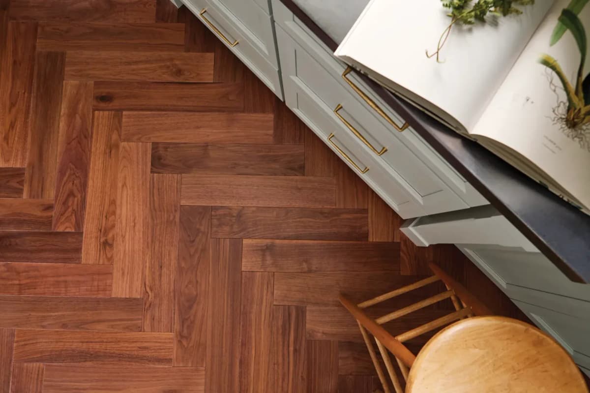 Rye American walnut herringbone flooring in a kitchen with sage-green cabinetry, viewed from above