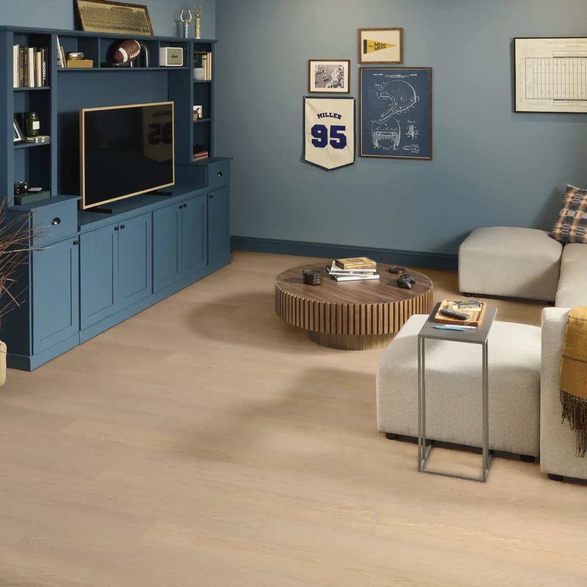 Best flooring for condos: Oceanfront luxury vinyl plank in a living room with built-in blue cabinetry and cream seating