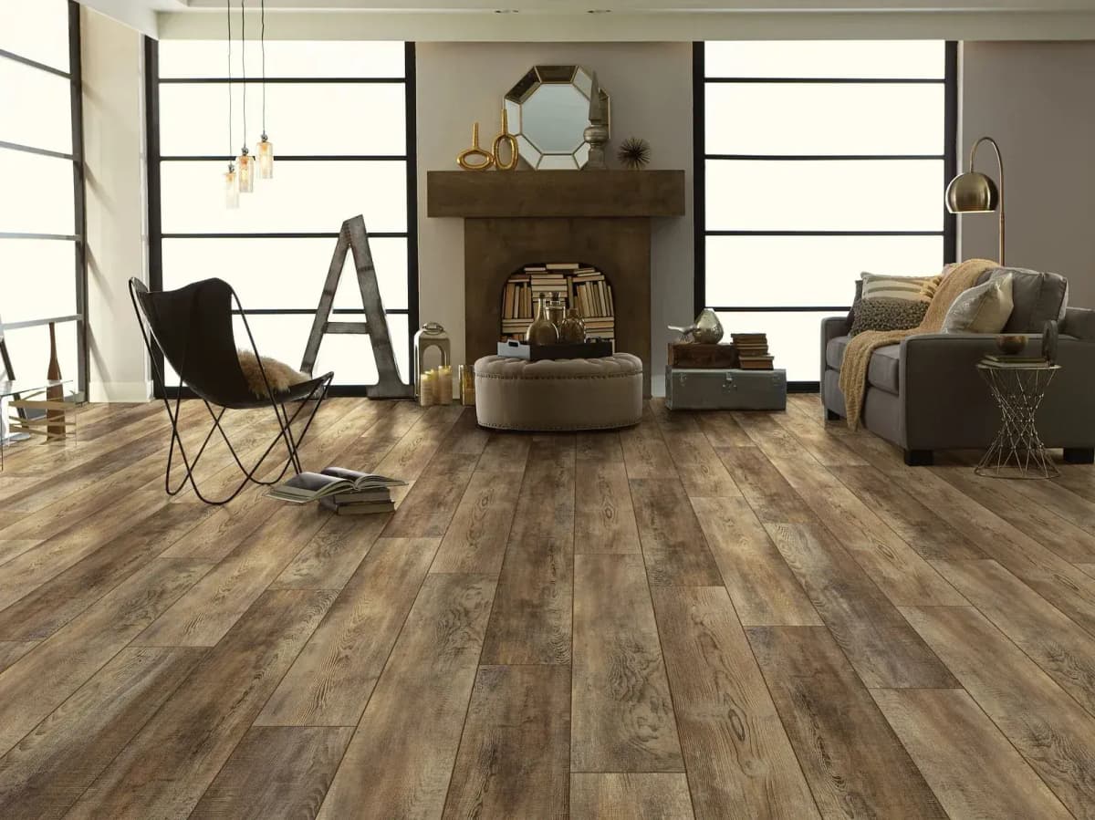 Saggio luxury vinyl plank flooring in a medium-toned, bright living room with a stone fireplace