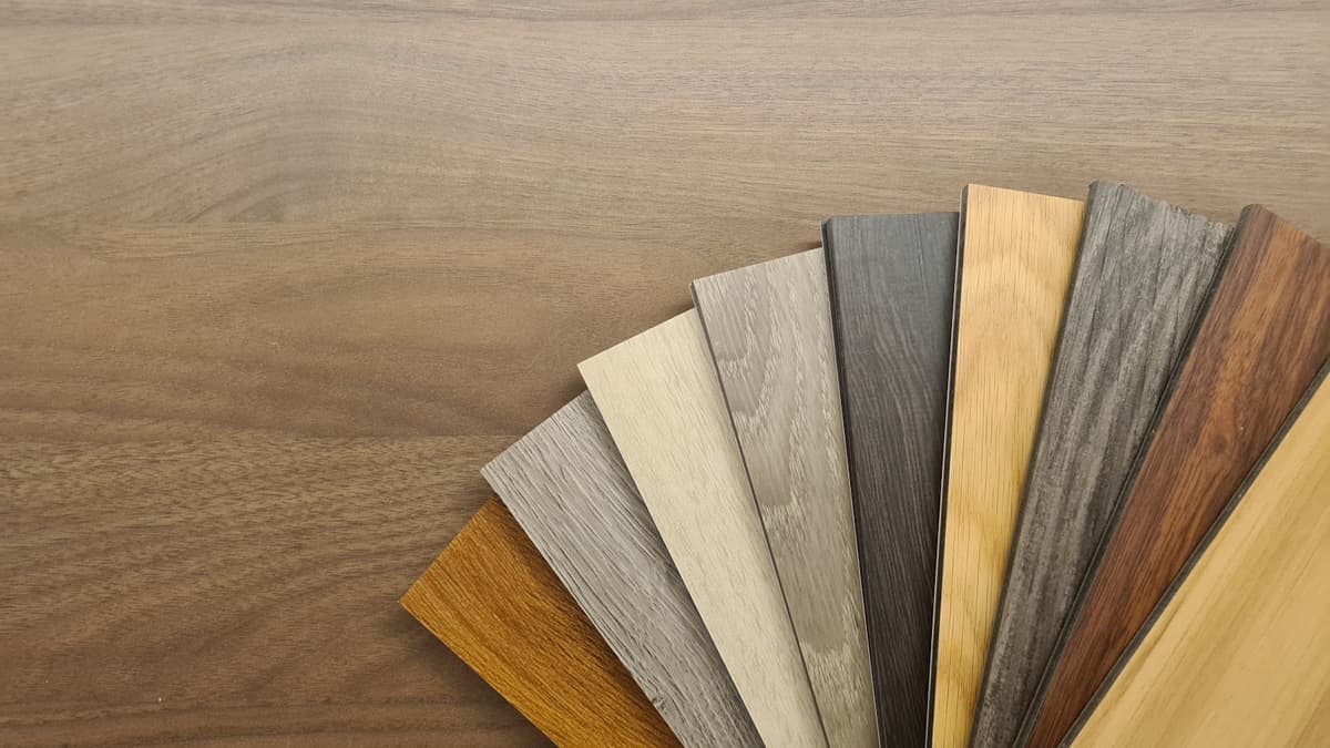 Close-up of a luxury vinyl plank showing the attached cork underlayment bonded to the underside