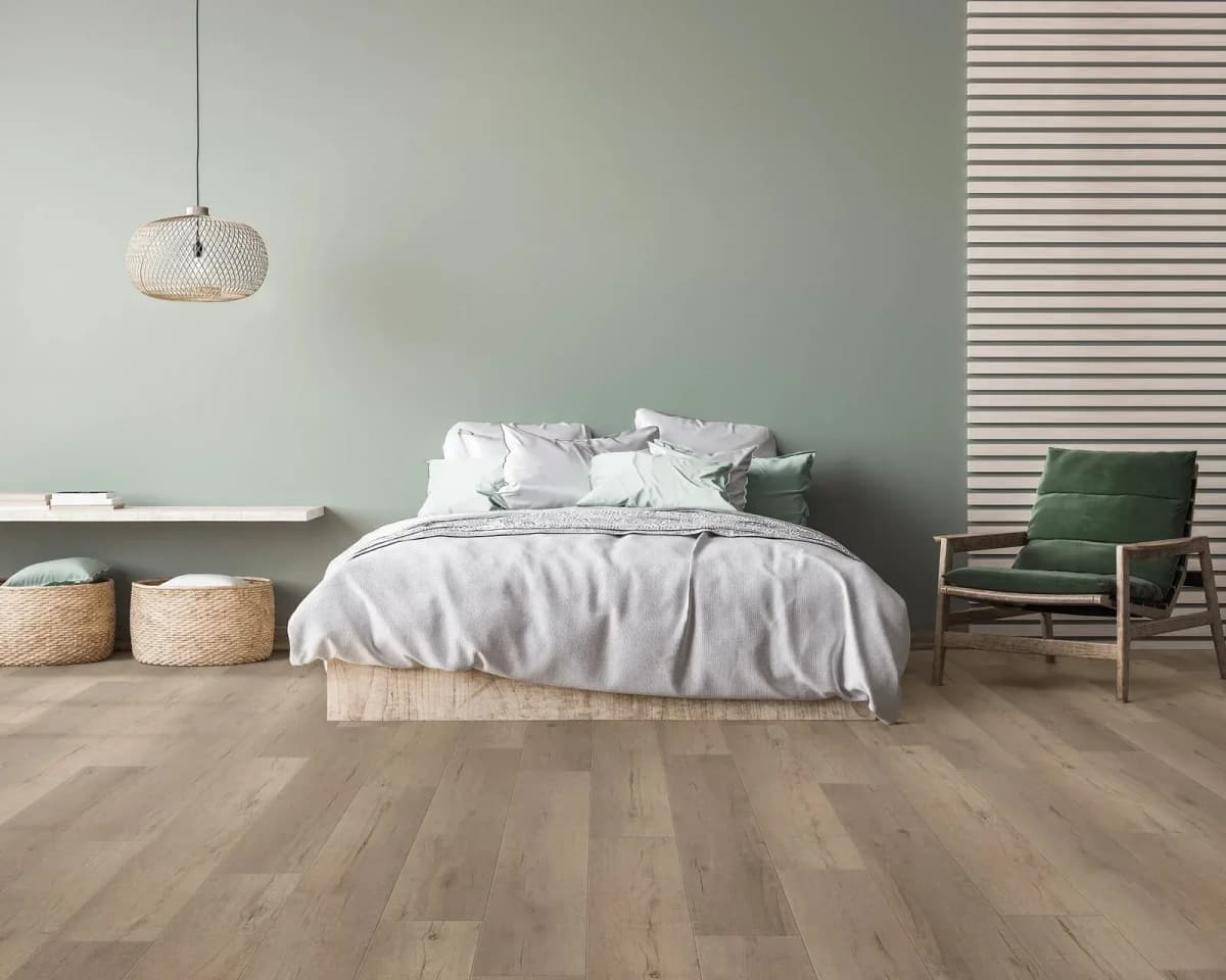 COREtec Miles Oak luxury vinyl plank flooring in a calm, light-filled bedroom with a wood bed frame