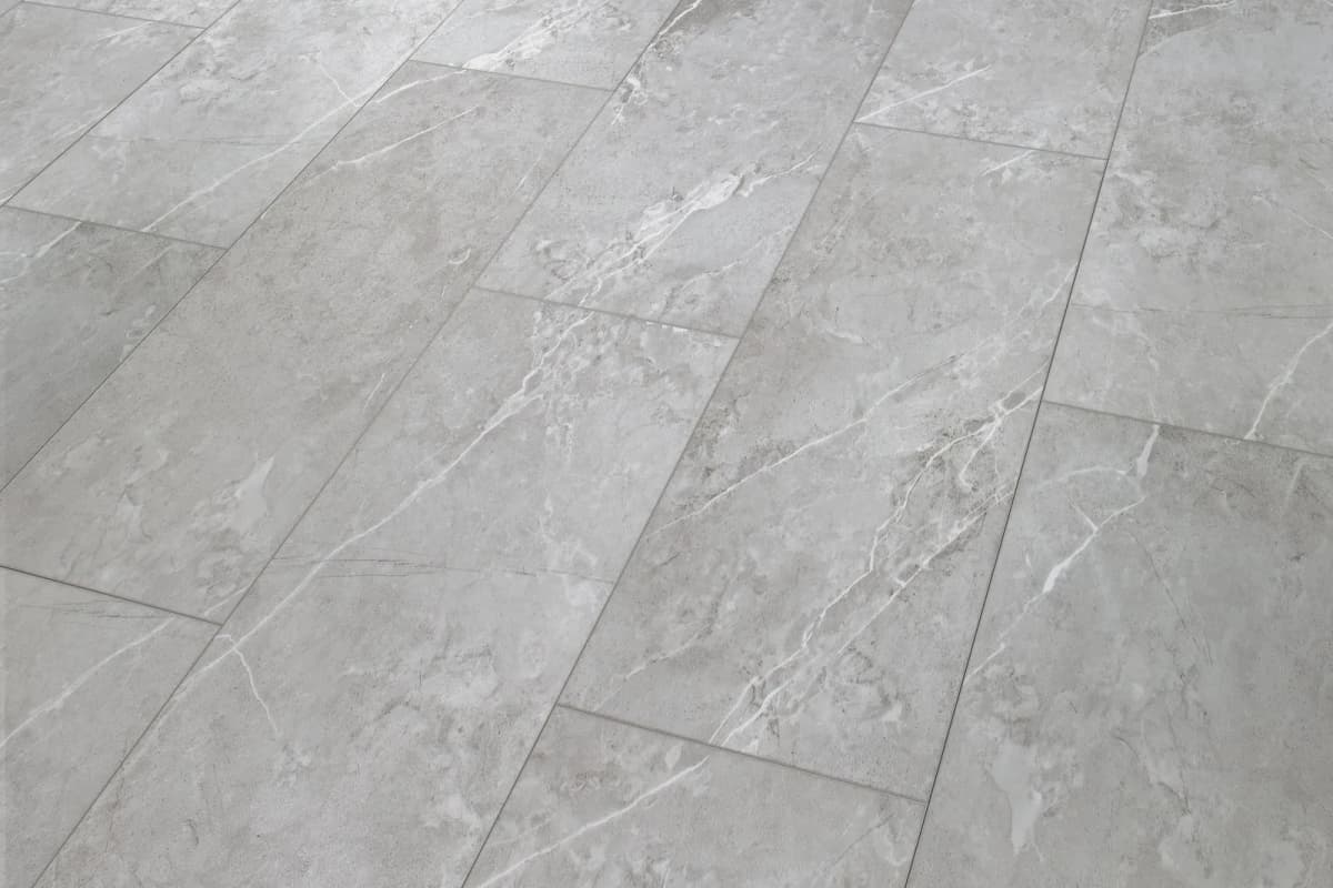 COREtec Pro Plus Enhanced Tile in Amani Marble, gray with white veining, laid in an offset pattern with crisp beveled joints.