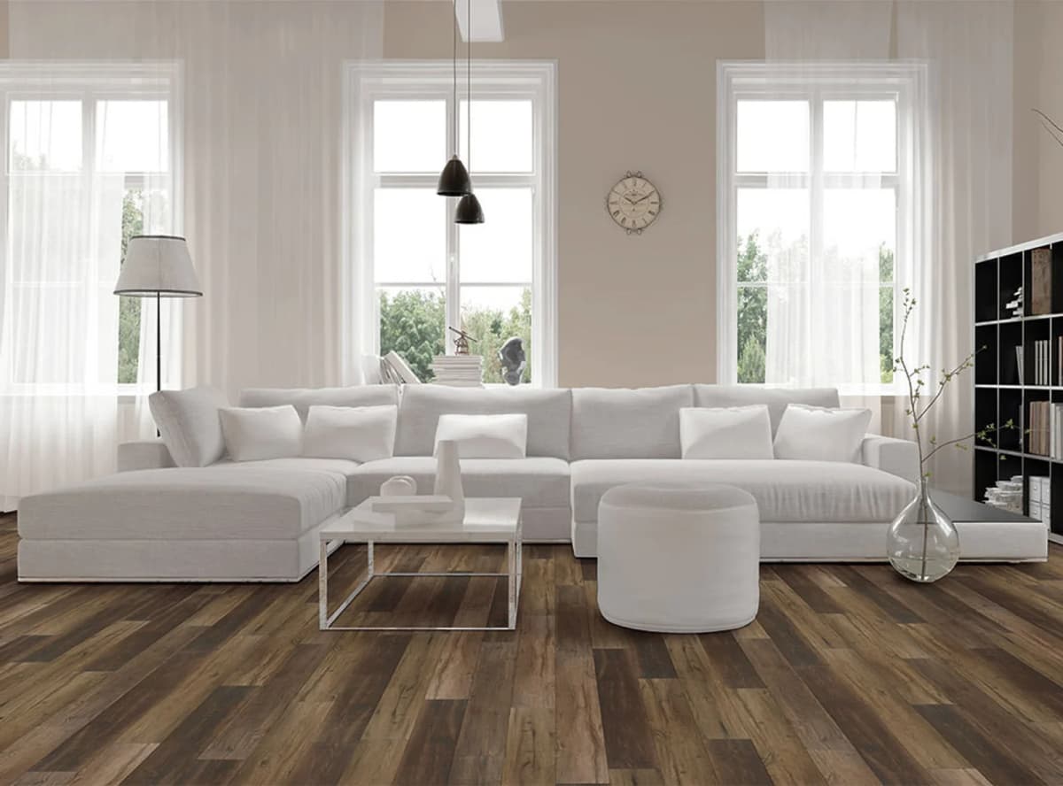 Warm brown COREtec Originals plank flooring with dark grain variation in a bright, minimalist living room