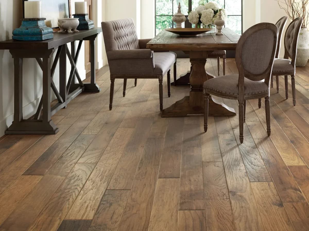 Fora hickory hardwood flooring spans a bright dining room with a wood table and upholstered chairs