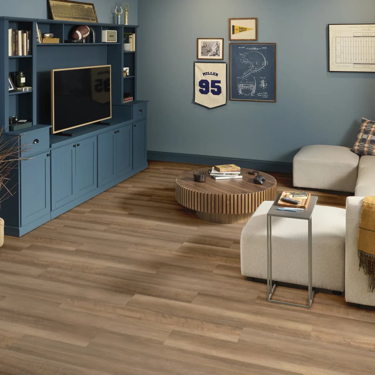 Shaw Endura Plus waterproof vinyl plank in Tawny Oak across a living room with a media console