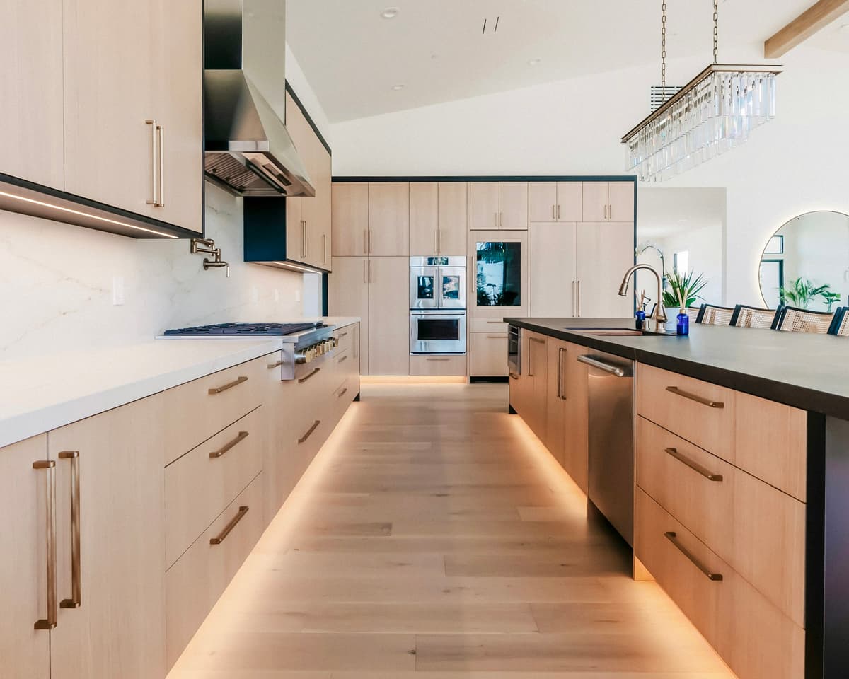 Engineered hardwood flooring in a modern kitchen with white cabinets and natural light