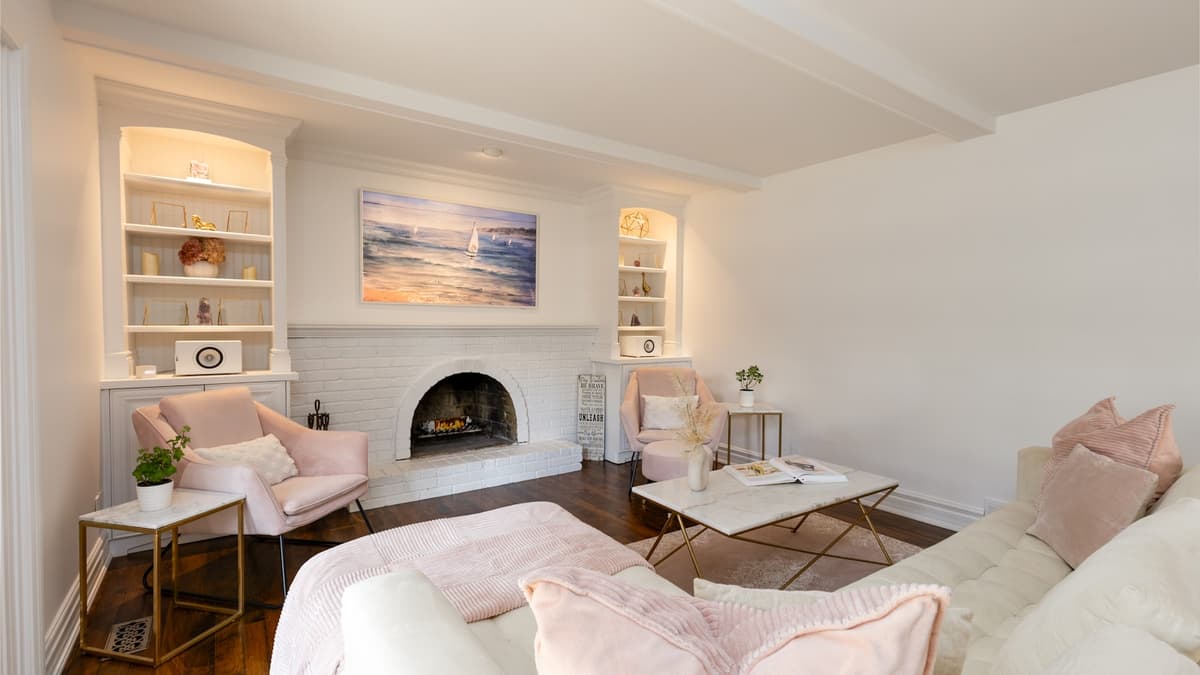 Wide-plank engineered hardwood flowing from a living room toward a staircase in a bright family home