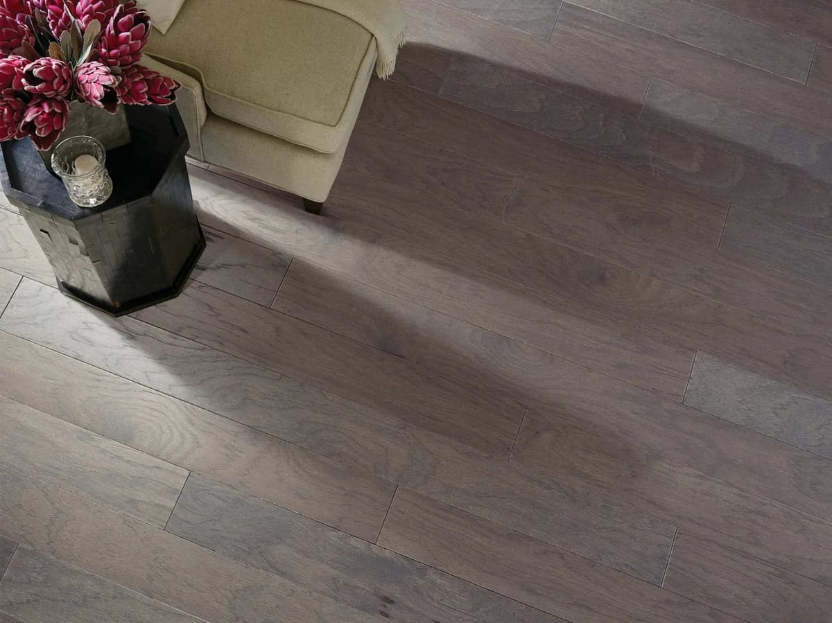 Sunlight raking across Shaw Northington Smooth hickory flooring in Greystone, showing how natural light shifts a floor's color and grain