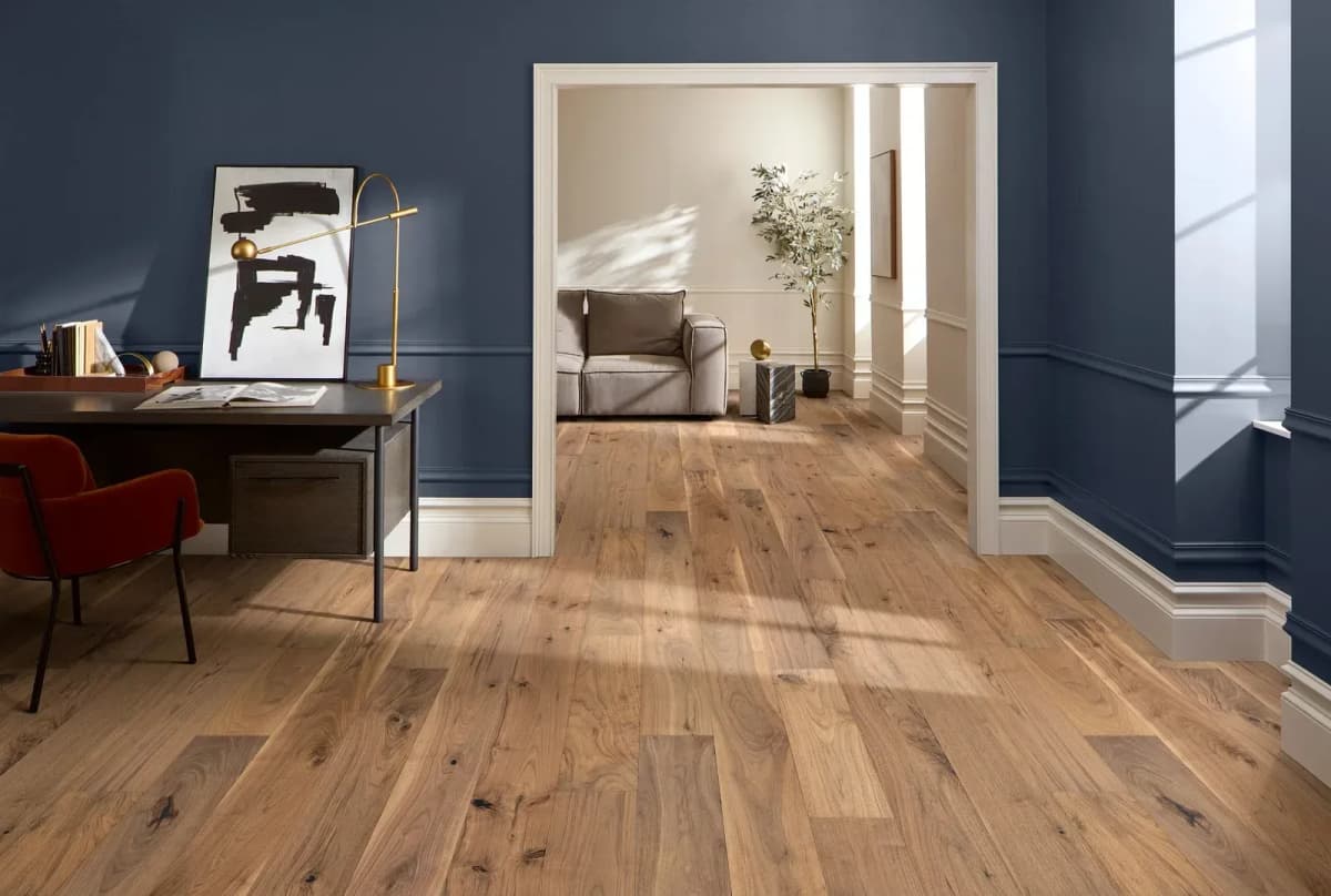 Sirocca American walnut hardwood flooring runs from a home office through an open doorway into an adjoining room