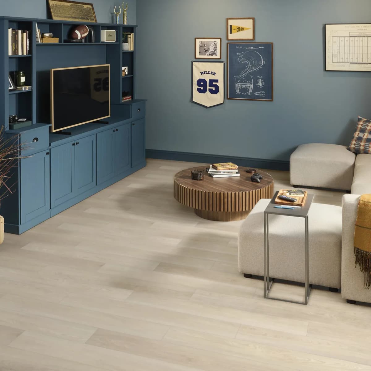 Light wood-look vinyl plank flooring filling a living room with a media console