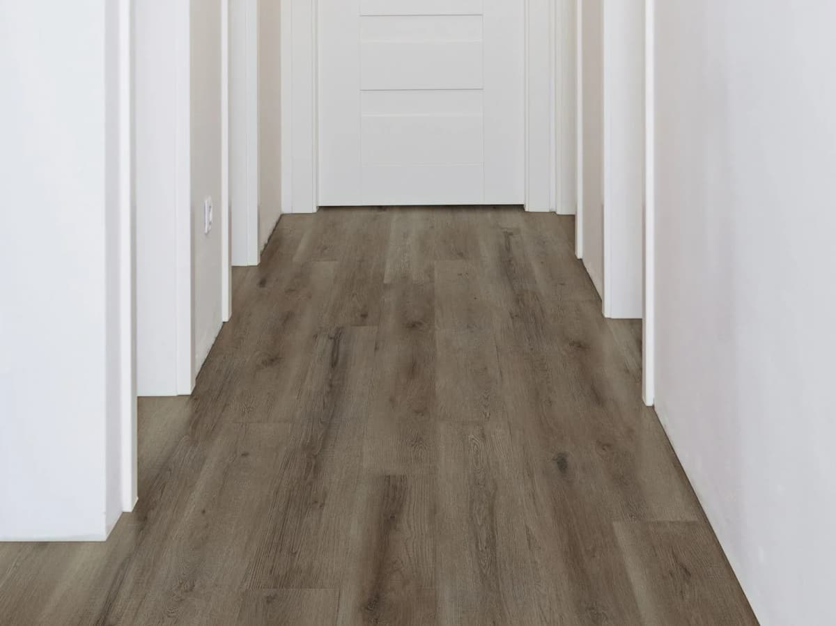 Wood-look vinyl plank flooring running the length of a hallway toward a door