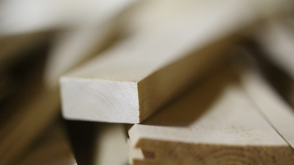 Cross-section of engineered hardwood beside luxury vinyl plank, the two constructions most commonly installed on stair treads