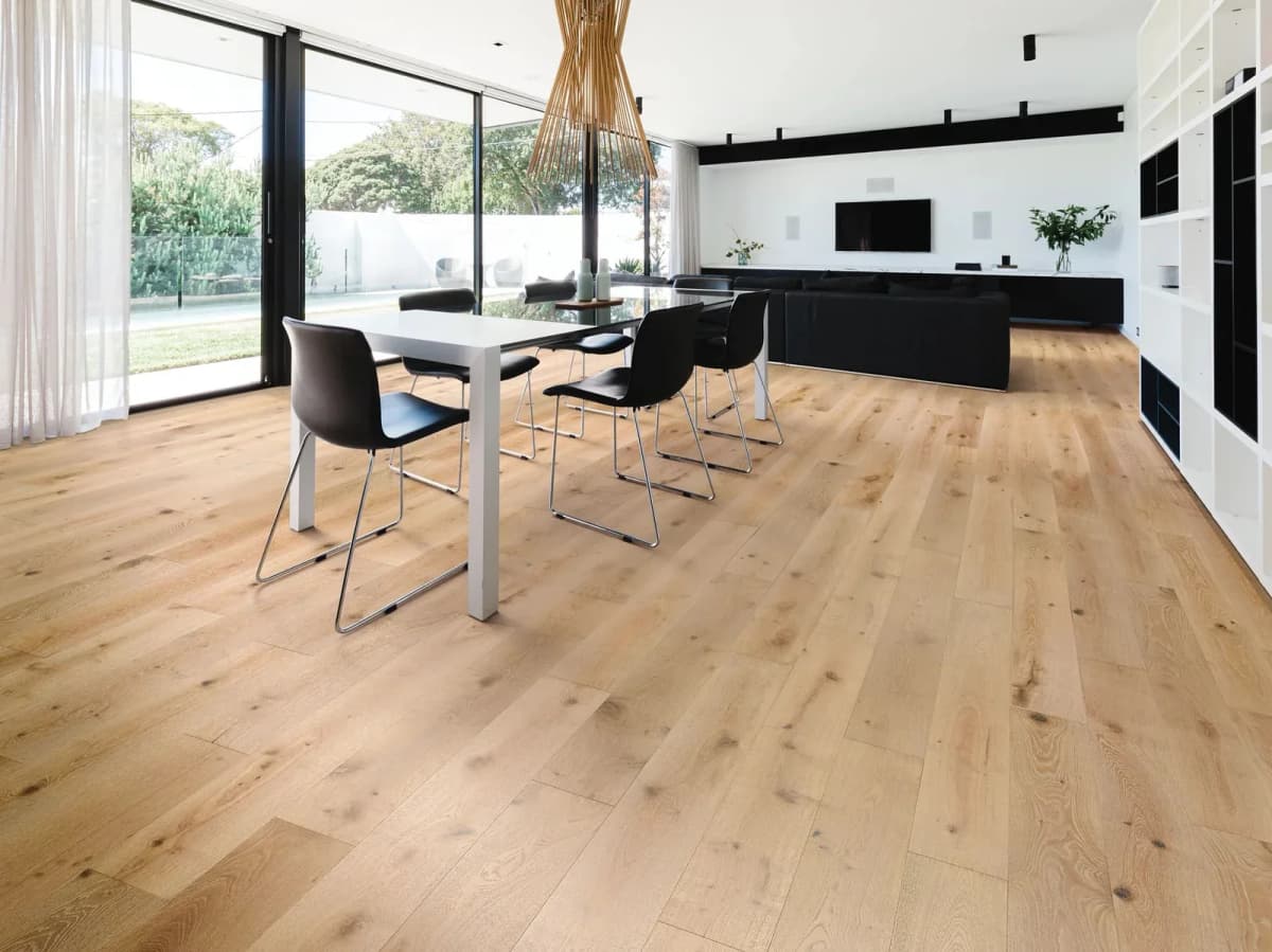 Shaw Expressions white oak flooring runs through an open dining and living space with a black dining table.