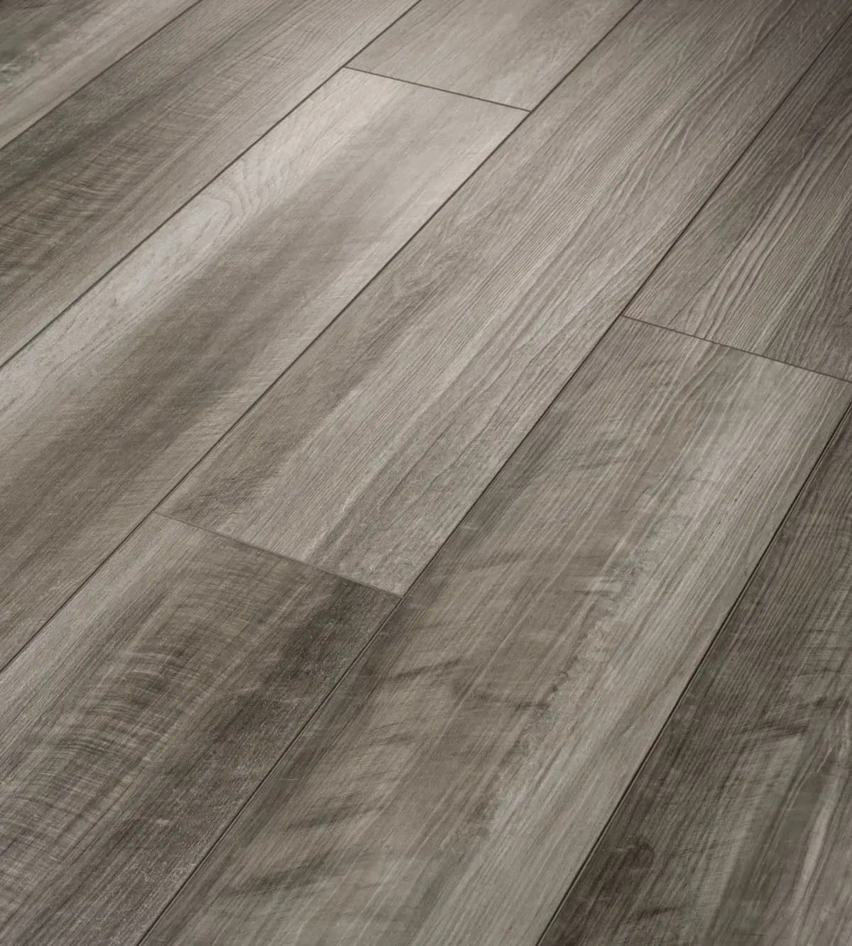 Close-up angled view of Oyster Oak Shaw luxury vinyl plank showing wood grain texture and plank edges
