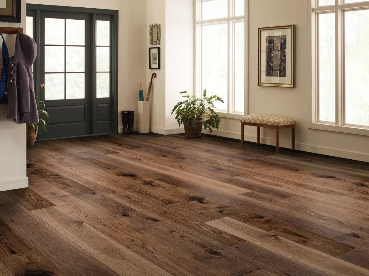 Anderson Tuftex wide pecan plank flooring with a bench and coat hooks in a bright entryway.