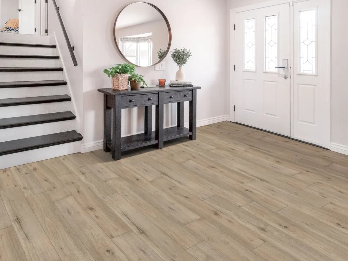 Shaw luxury vinyl plank flooring in a warm greige tone leads through a bright entryway.