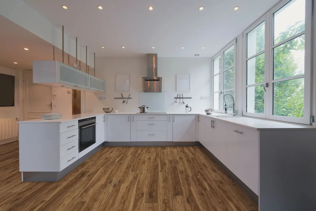 Medium brown luxury vinyl plank flooring with white cabinetry fills a modern kitchen.