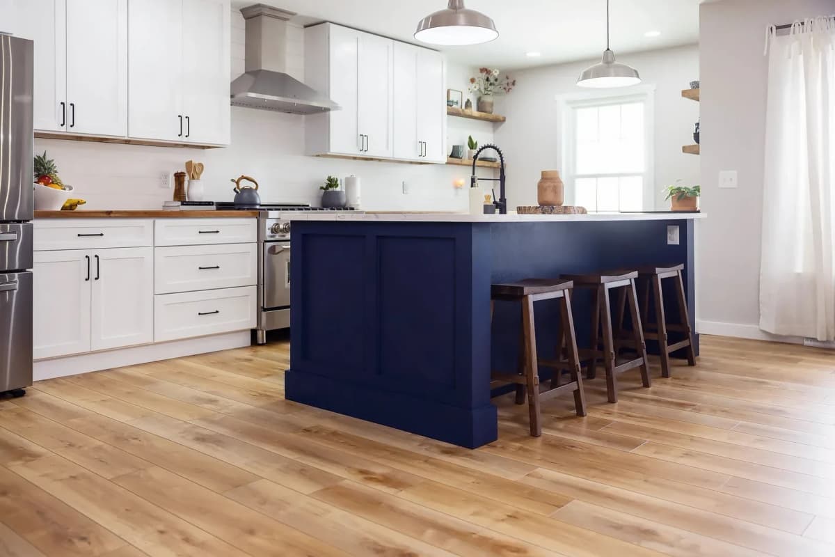 COREtec luxury vinyl plank flooring in a warm honey tone spans a bright kitchen.