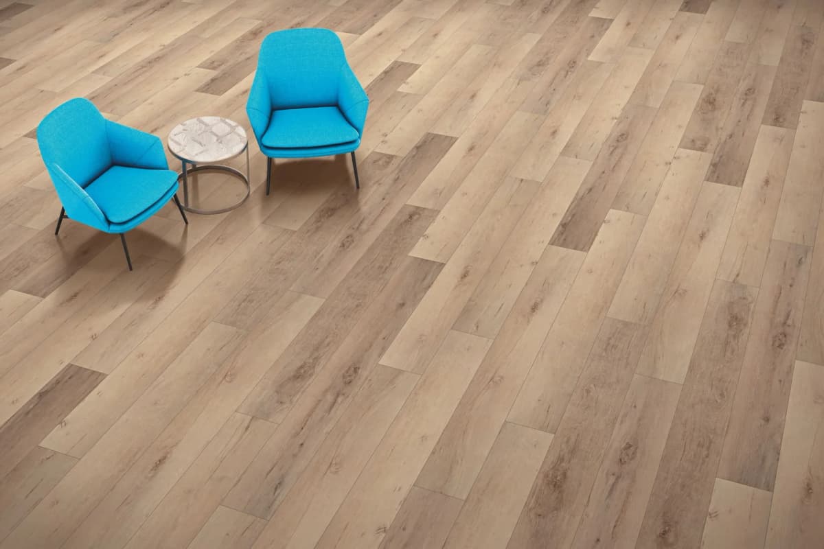 COREtec Pro Enhanced in Madrid Oak laid in a staggered pattern under two turquoise chairs and a side table