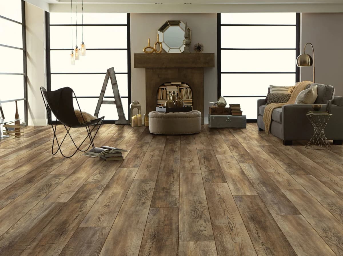 Shaw Pantheon HD Plus vinyl plank flooring in Saggio in a bright living room with a fireplace and large windows