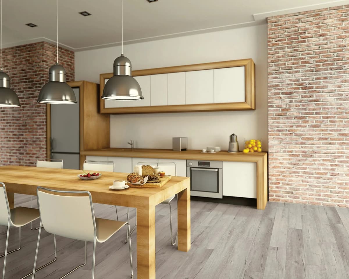 COREtec Pro Classics vinyl plank flooring in Chesapeake Oak in a modern kitchen with brick walls, wood cabinetry and pendant lights