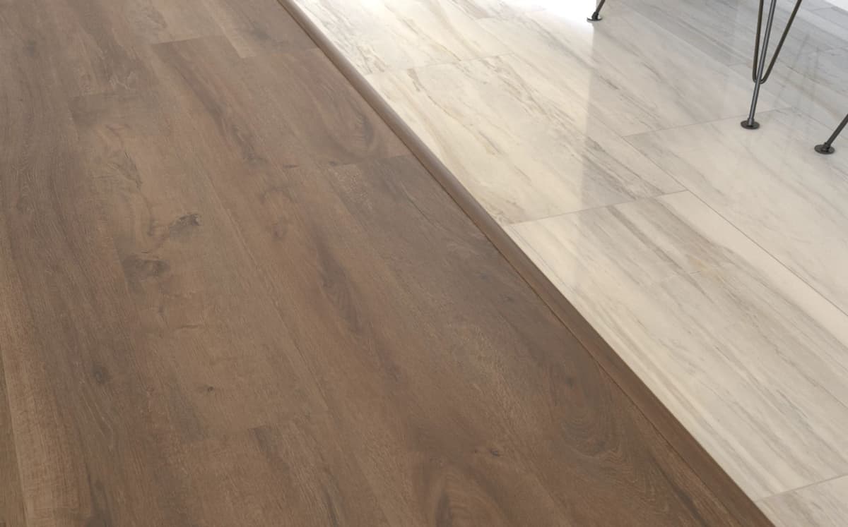 A T-molding bridging the seam where wood-look plank flooring meets a white tile floor of the same height